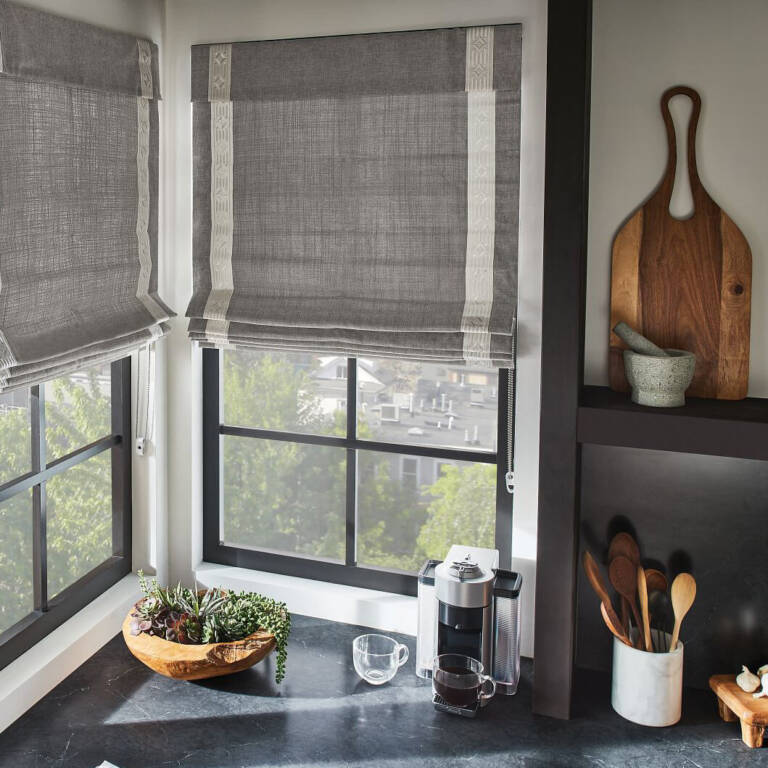 grey soft roman shades on windows in a european style kitchen