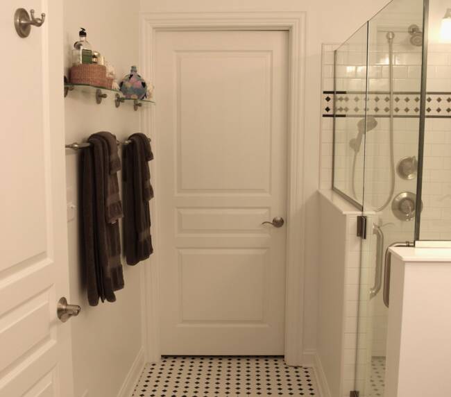 Bathroom with classic black and white mosaic tile flooring and white subway tile shower