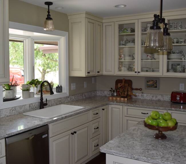 kitchen with cream cabinets, glass-front doors, granite countertops, and pendant lighting